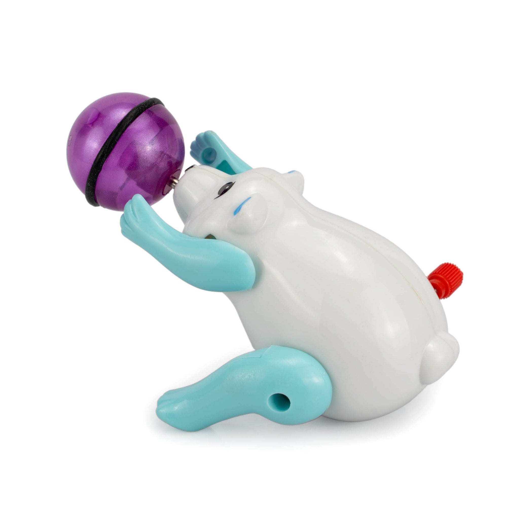 Toy seal with a purple ball on a white background