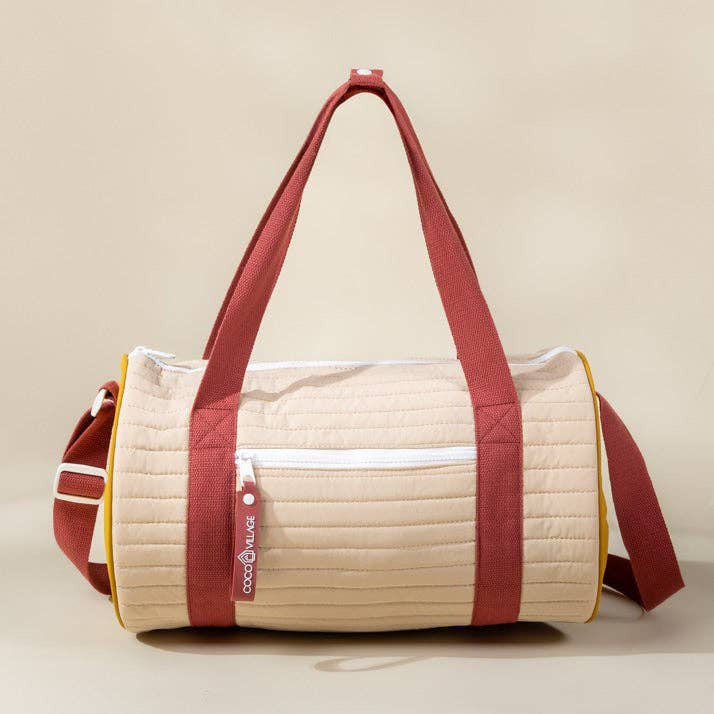 Beige and red duffel bag on a beige background
