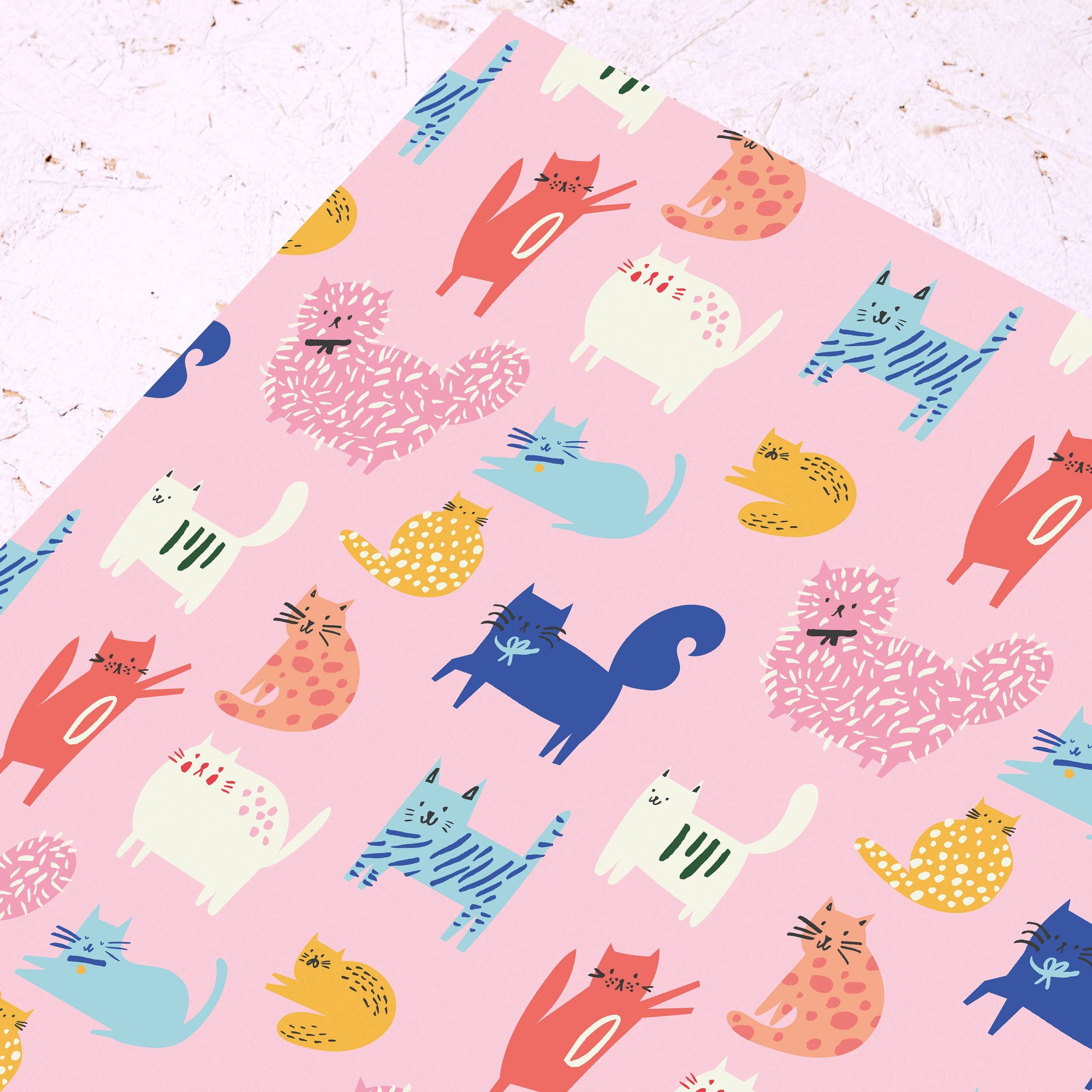 Pink fabric with colorful cat pattern on a light pink background