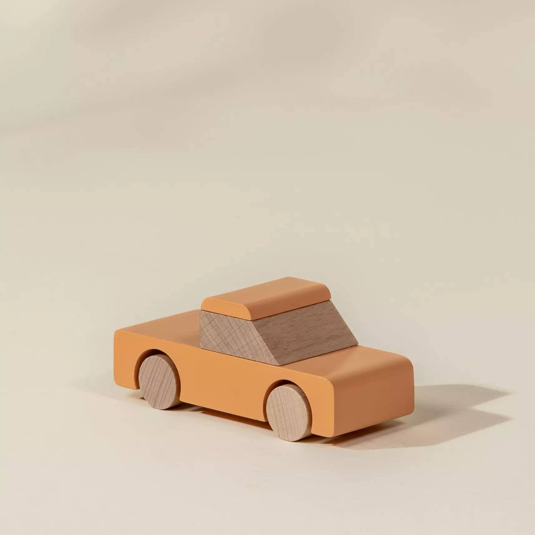 Wooden toy car on a beige background