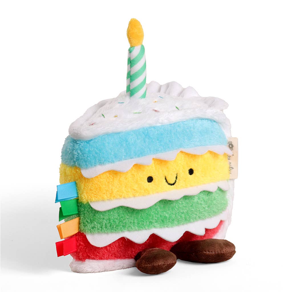 Plush toy resembling a birthday cake with a candle on a white background