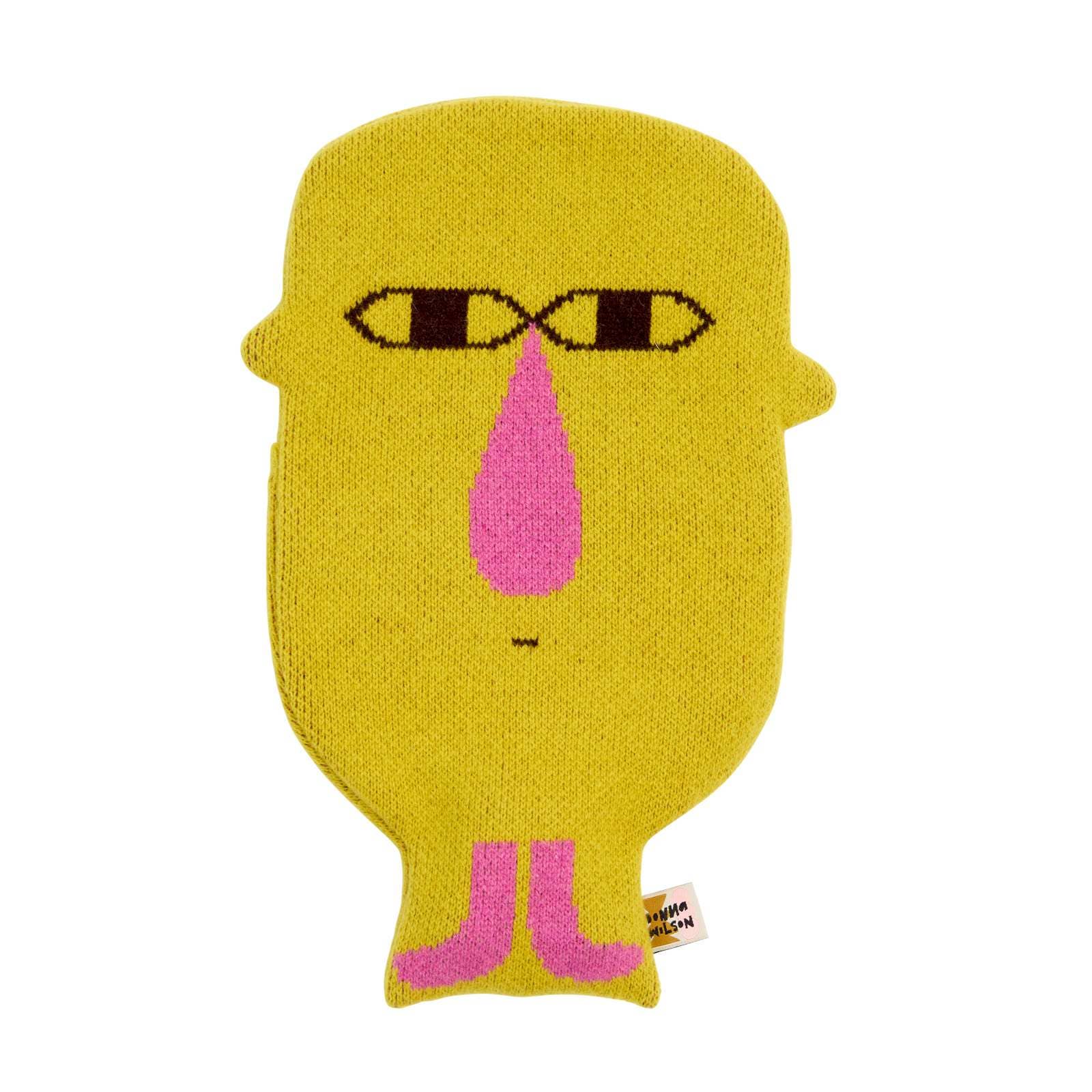 Yellow knitted face with black and yellow eyes and a pink nose on a white background