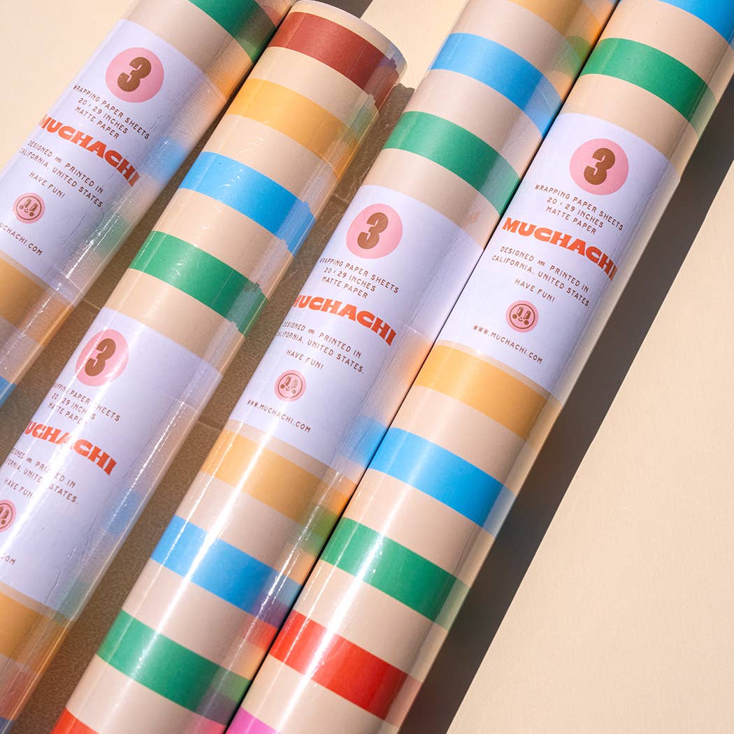 Four rolls of colorful paper with 'MUCHACHI' branding on a beige background