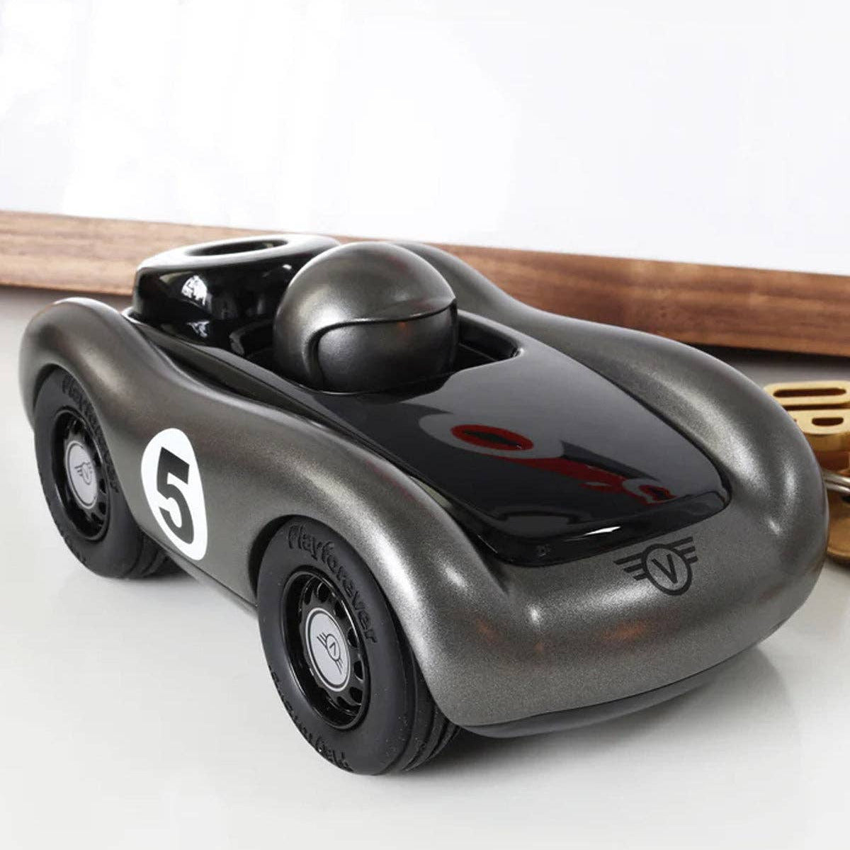 Black toy car with number 5 on a white surface