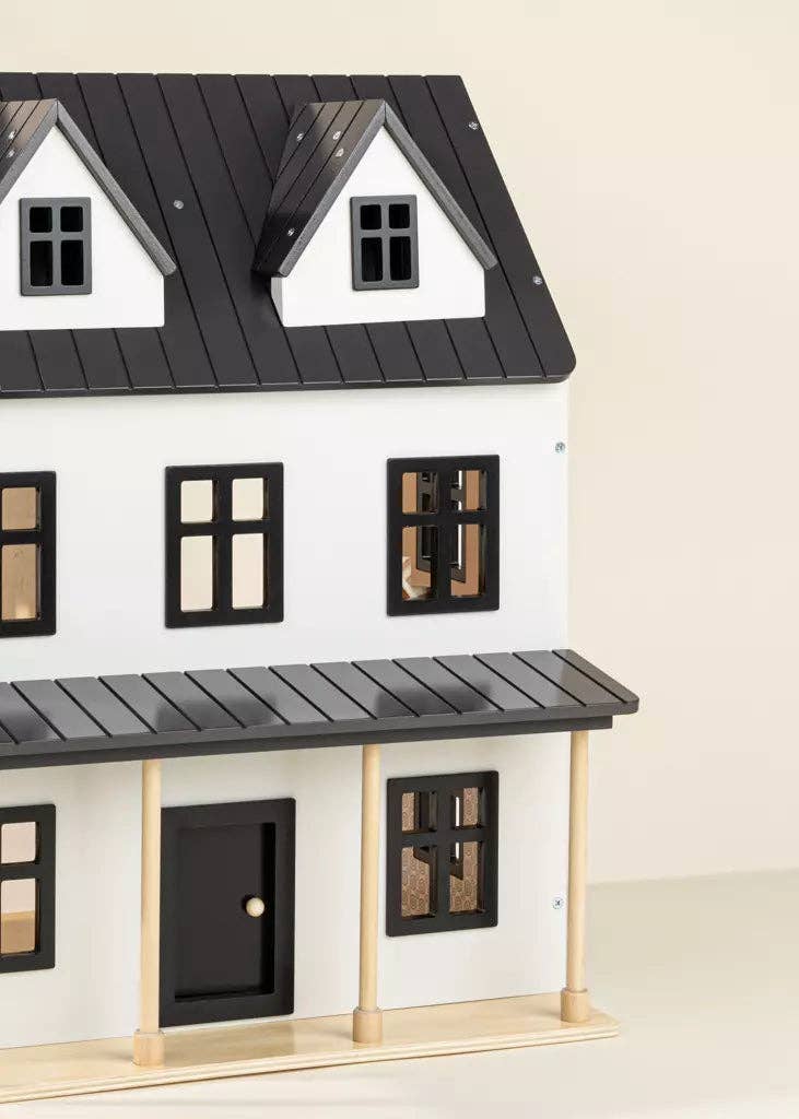 Model of a house with black roof and white walls on a beige background