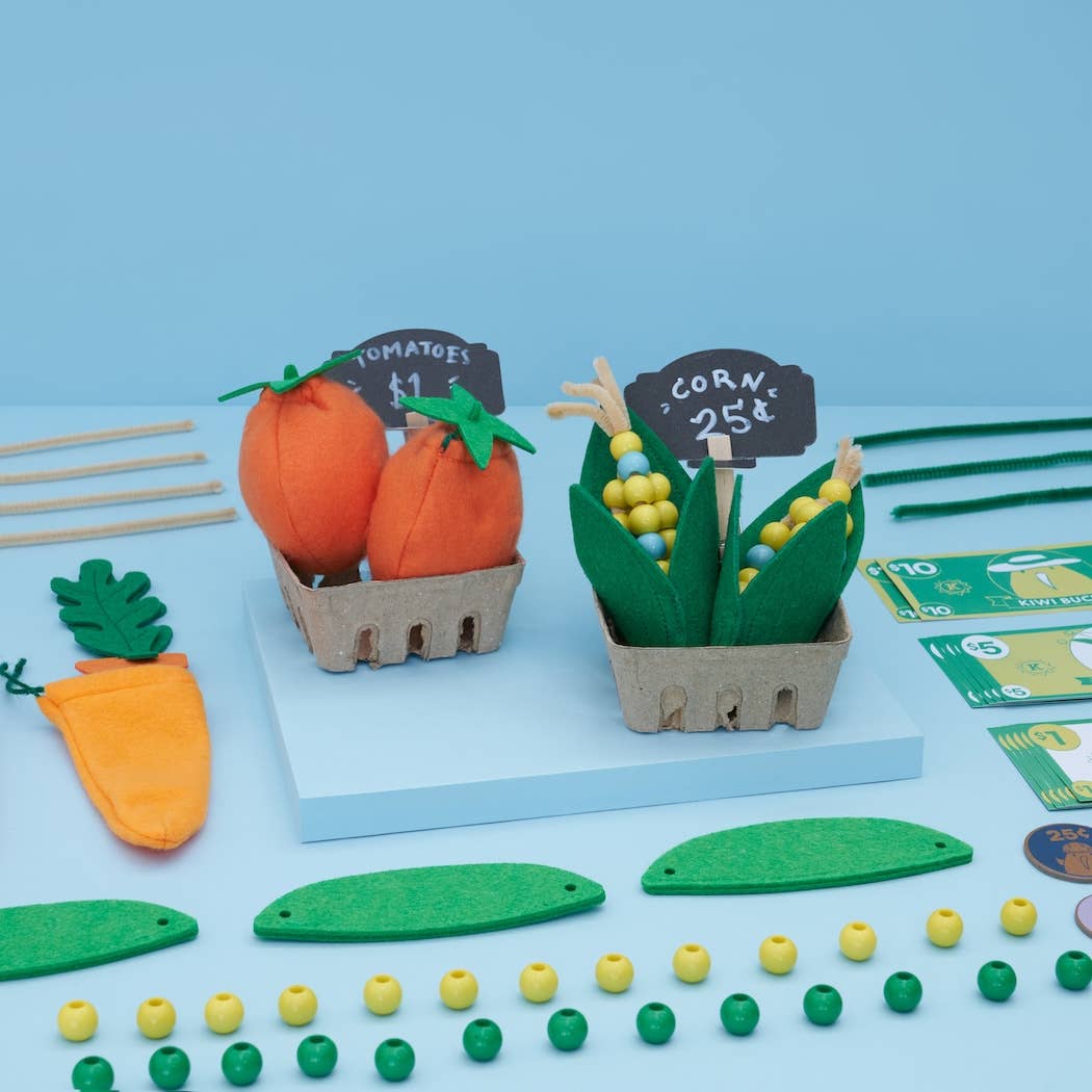 Toy vegetables set on a blue background with small signs and money.