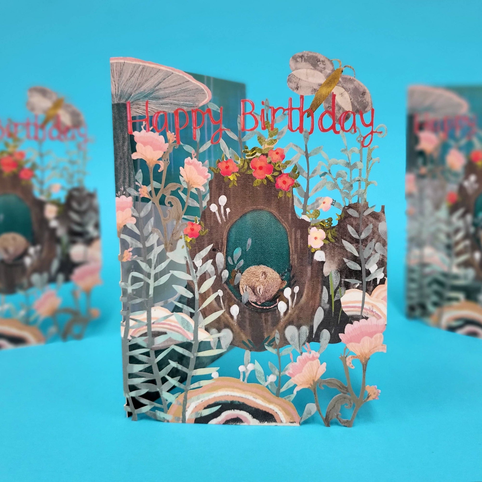 Pop-up birthday card with a forest design and flowers on a blue background