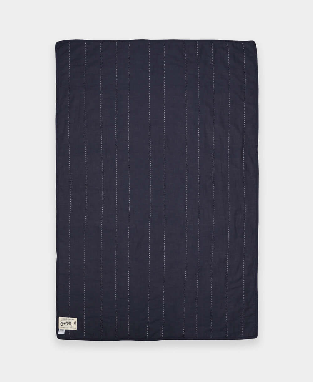 Navy quilt with white pinstripes on a white background