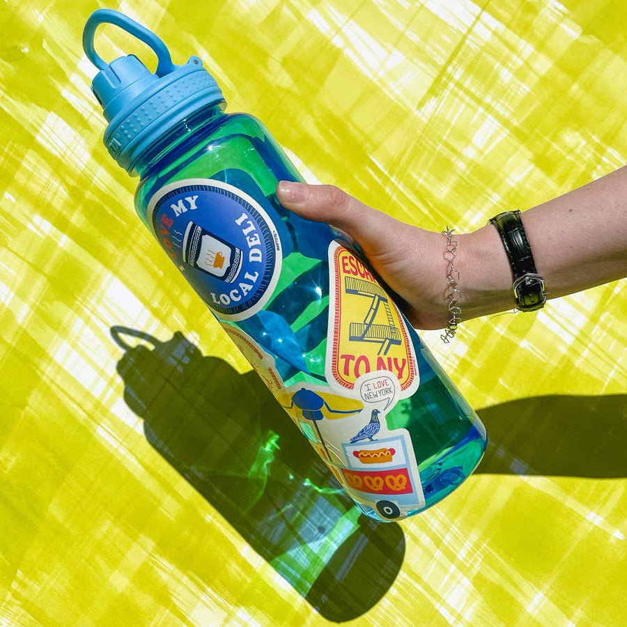 Person holding a colorful water bottle with branding on a yellow background