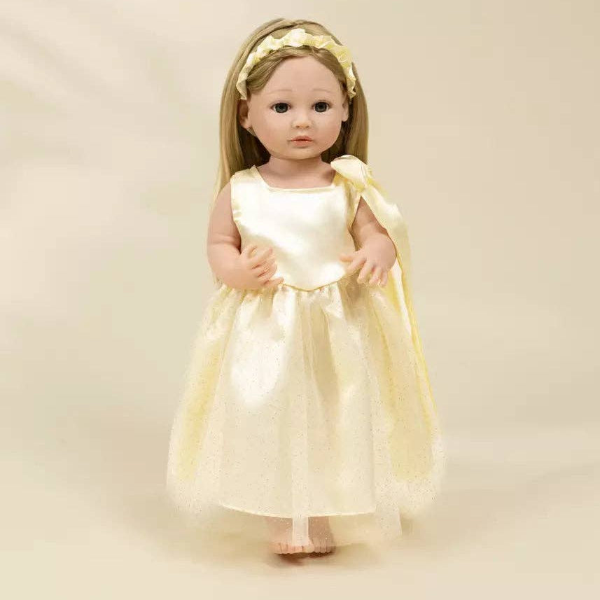 Doll in a yellow dress with a matching headband on a beige background