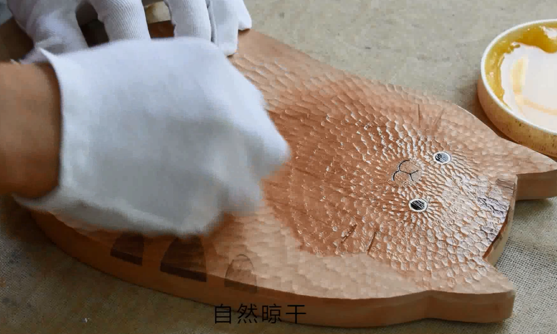 Person wearing gloves cleaning a wooden surface with a sponge