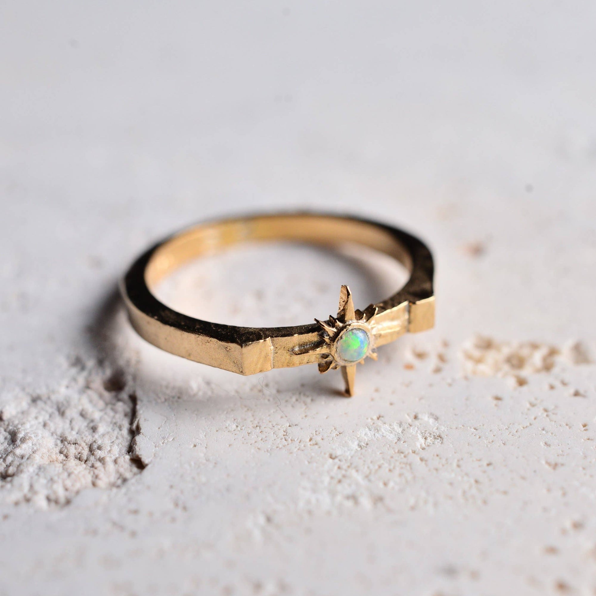 Gold ring with a gemstone on a textured surface