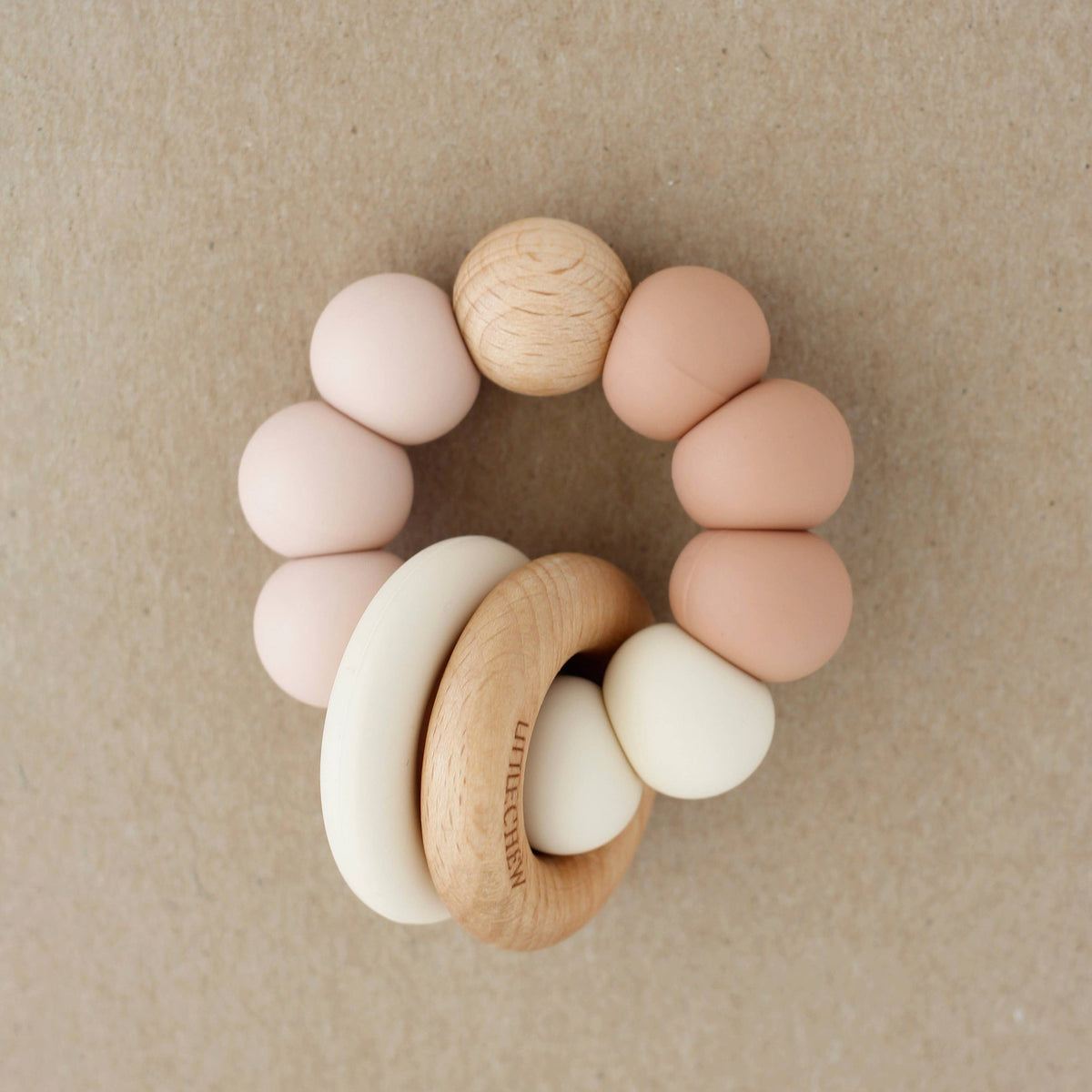 Colorful baby teething ring on a beige background