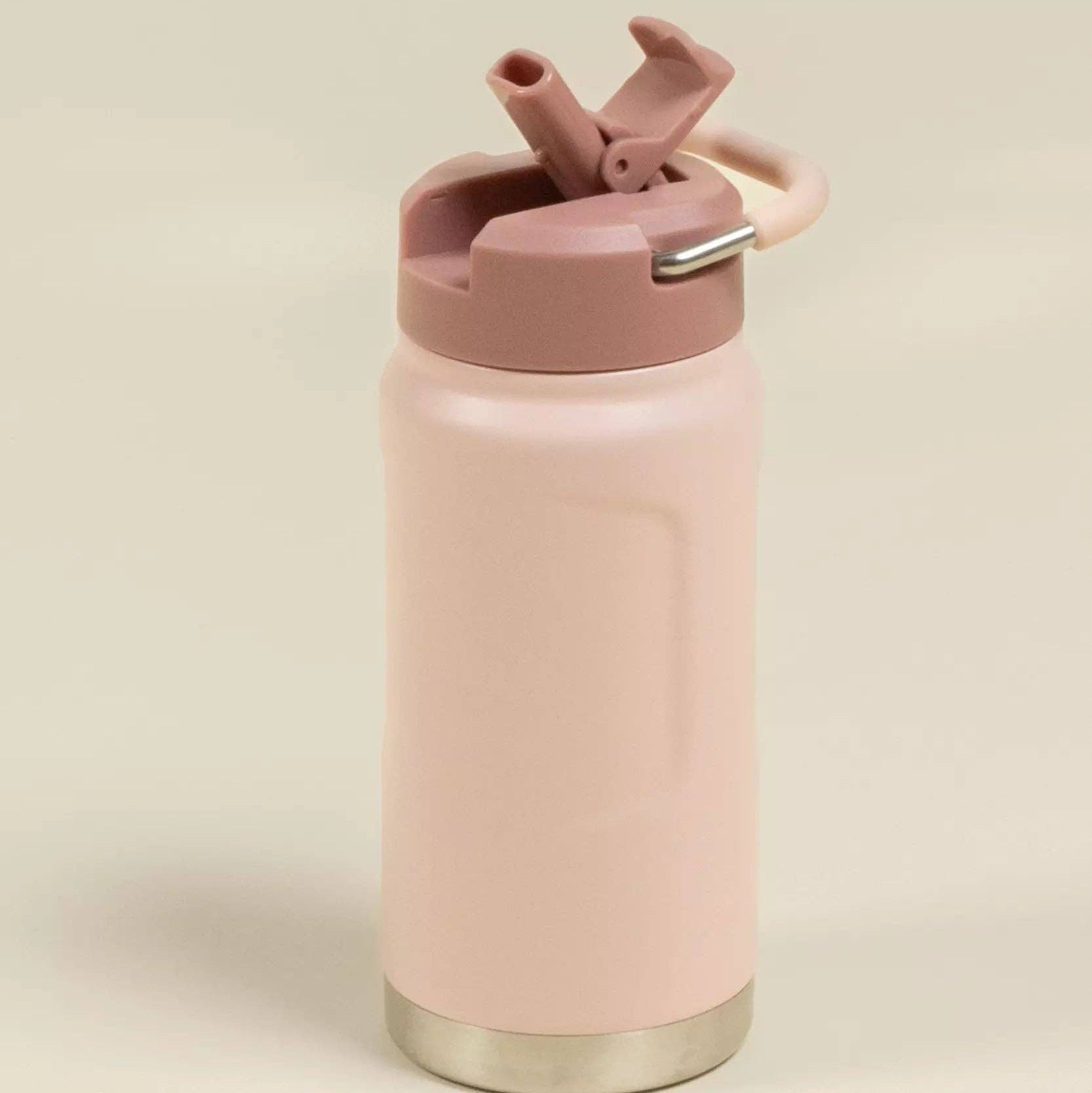 Pink water bottle with a gold base on a beige background