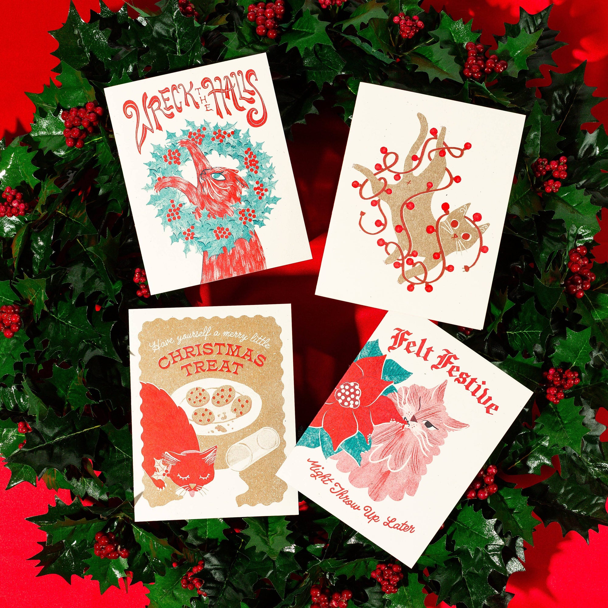 Four Christmas-themed cards on a red background with holly leaves and berries.