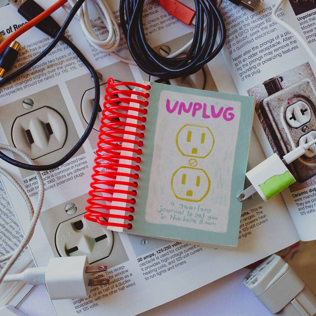 Electrical accessories including cables and a 'UNPLUG' card on a magazine background