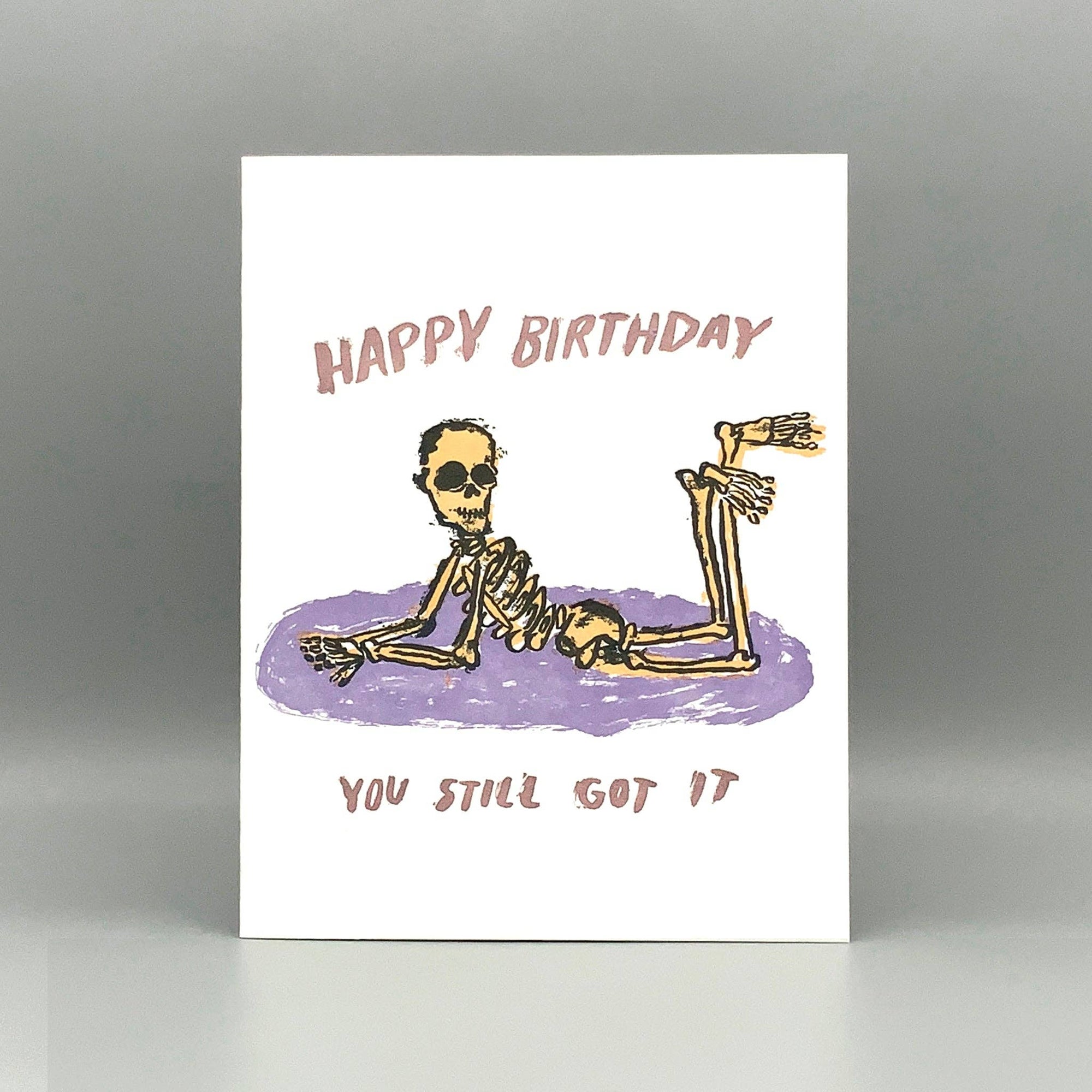 Birthday card with skeleton illustration and humorous text on a white background