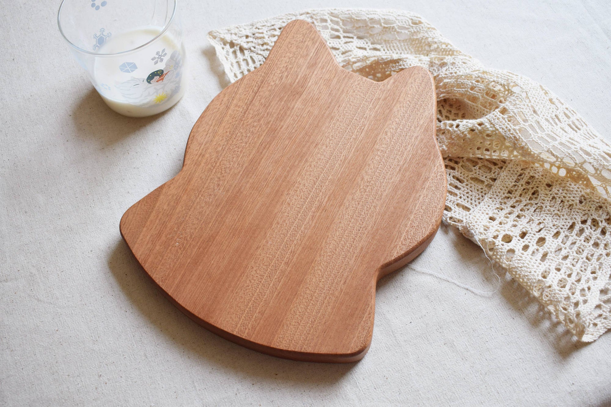 Wooden cutting board on a light surface with a lace cloth