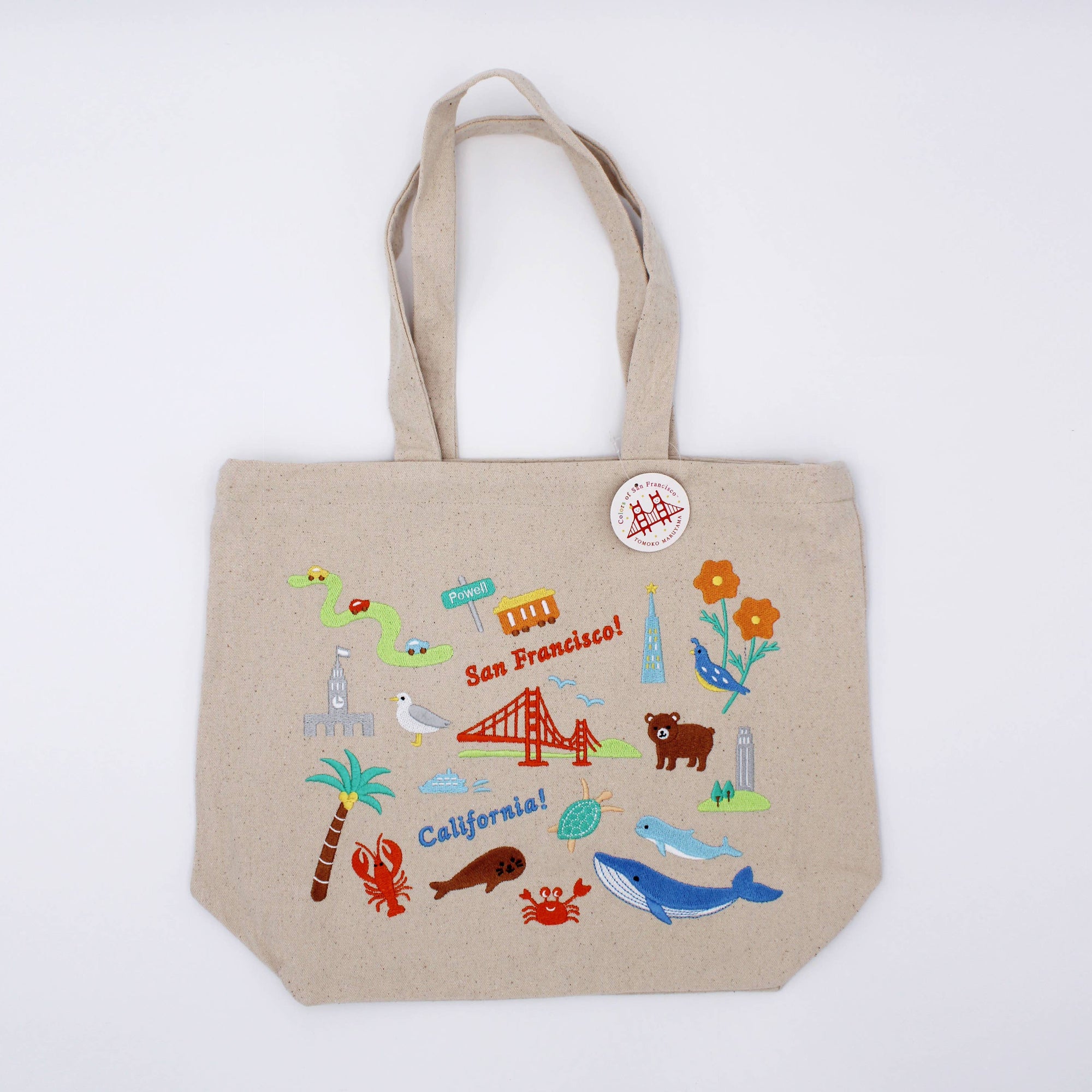 Beige tote bag with colorful illustrations on a white background