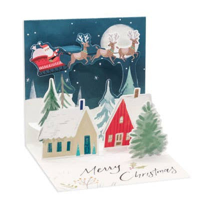 Christmas card with Santa Claus in a sleigh over a snowy village