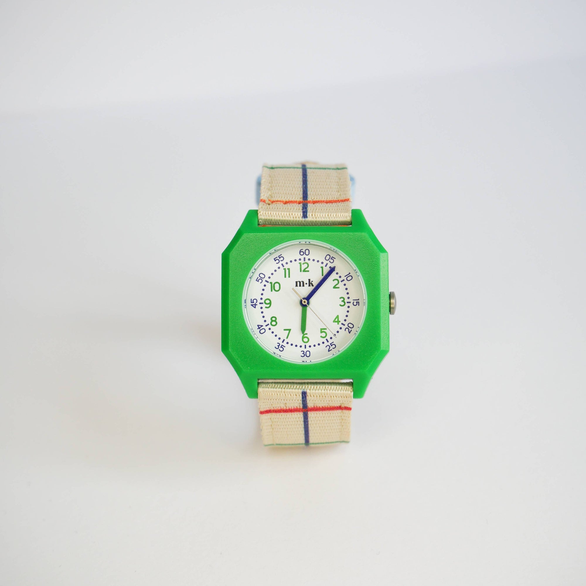 Green watch with a colorful strap on a white background