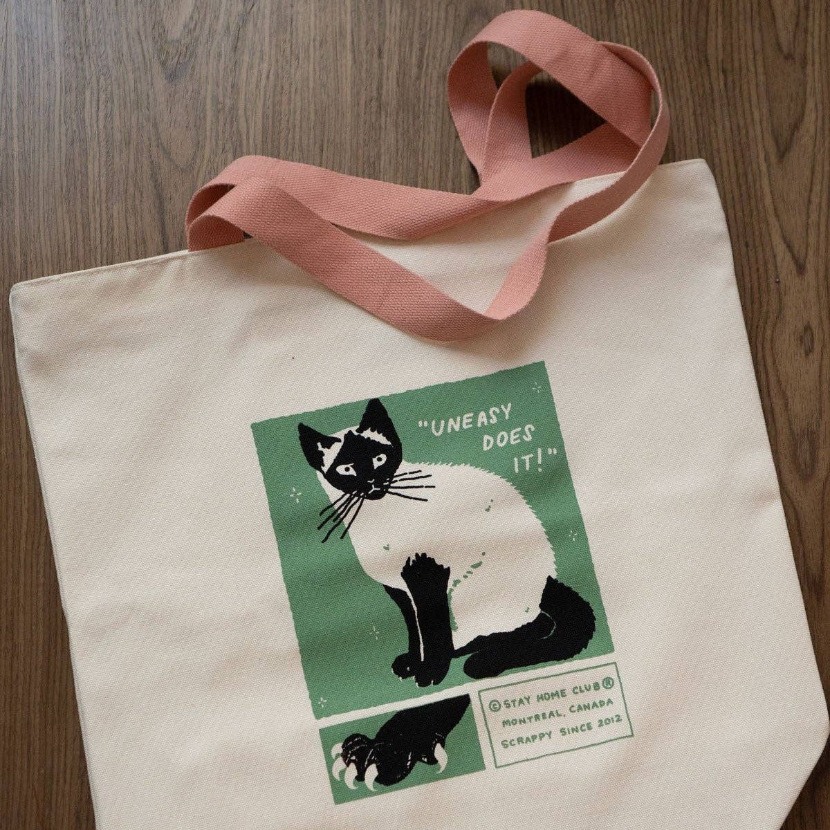 Tote bag with a cat illustration on a wooden surface