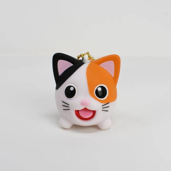 Cat-shaped keychain with black, orange, and white colors on a light gray background