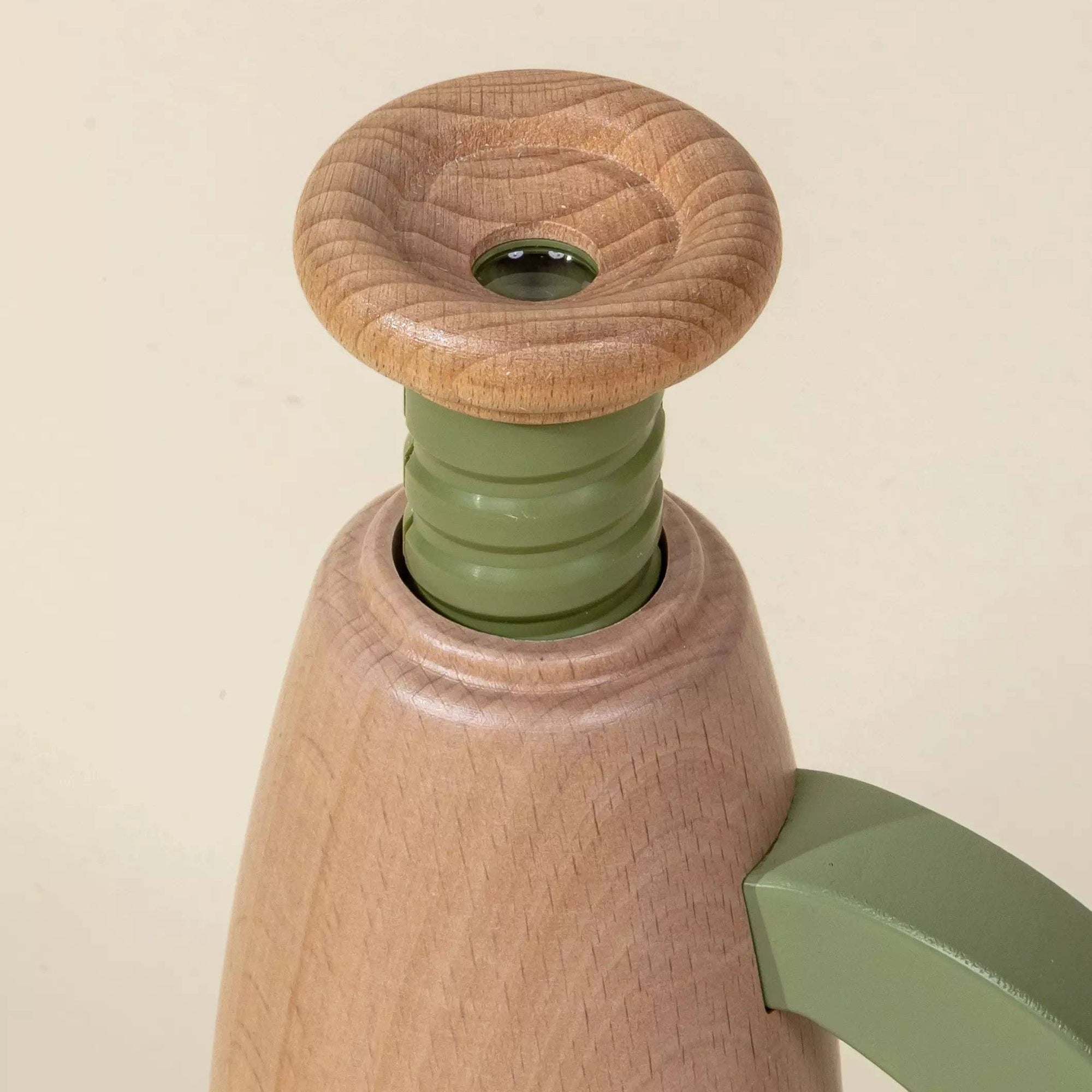 Wooden and green kitchen tool on a beige background