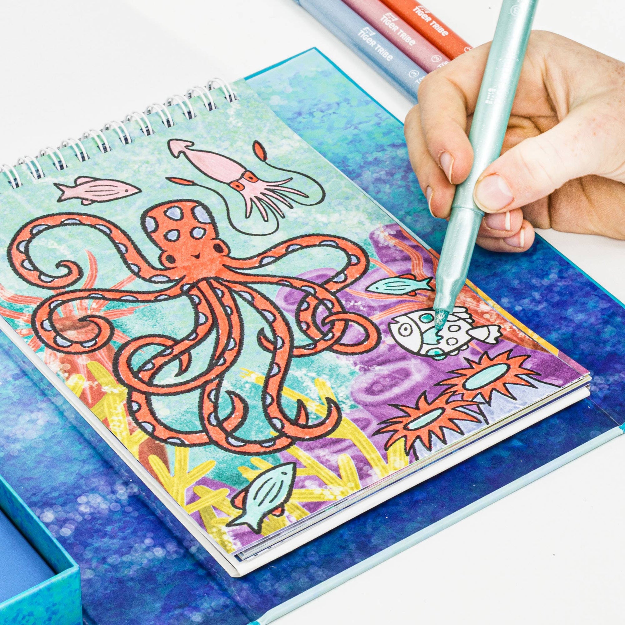 Coloring book with an octopus design, being colored with a pen.