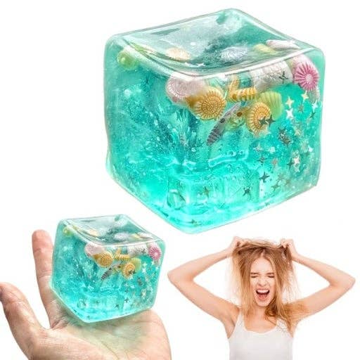 Clear blue cube filled with sea-themed toys, held by a hand and shown with a person wearing it.