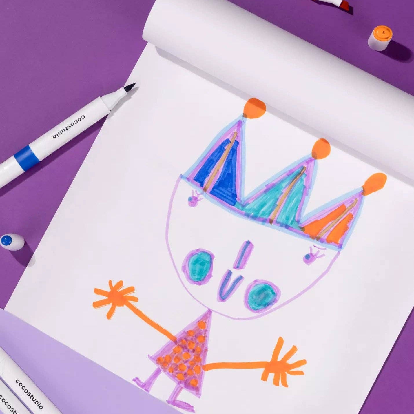 Colorful drawing of a character with a crown on a purple background with Crayola markers.