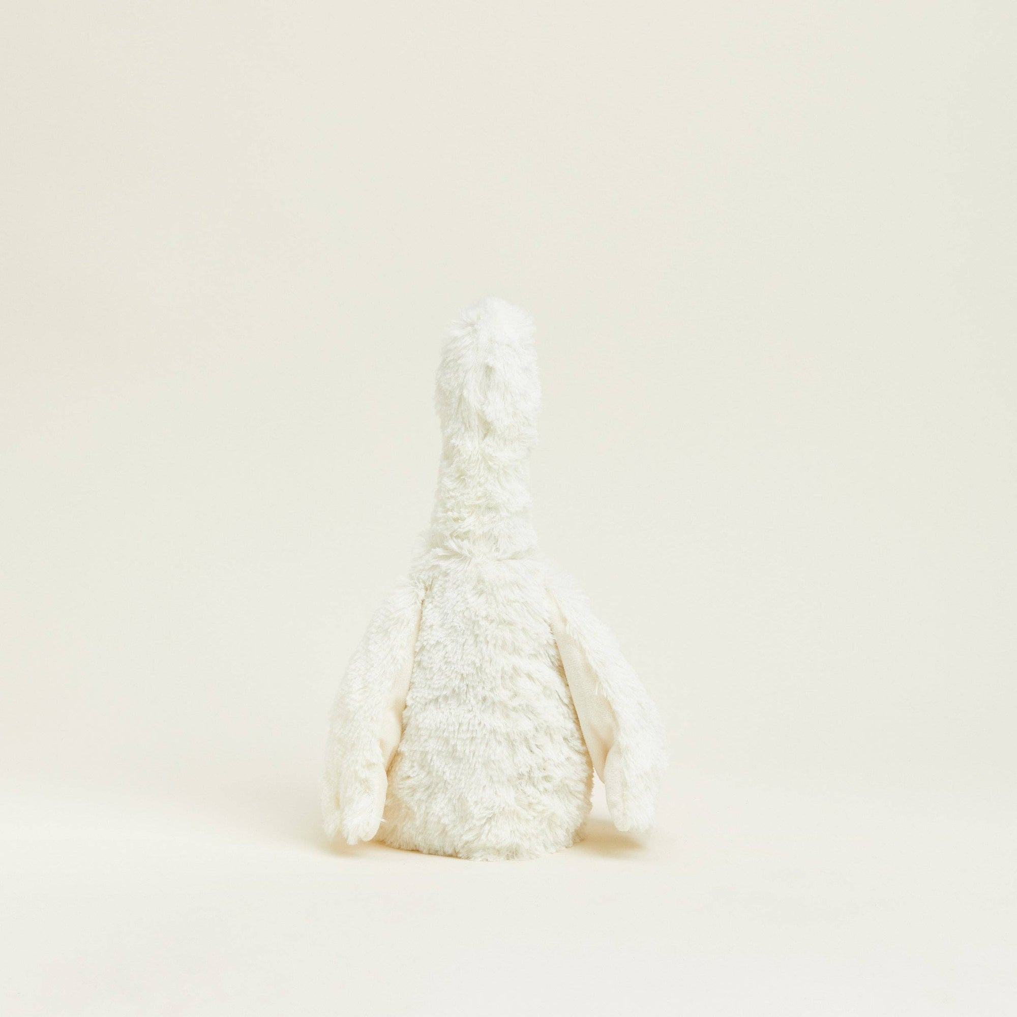 White decorative object resembling a rabbit on a beige background