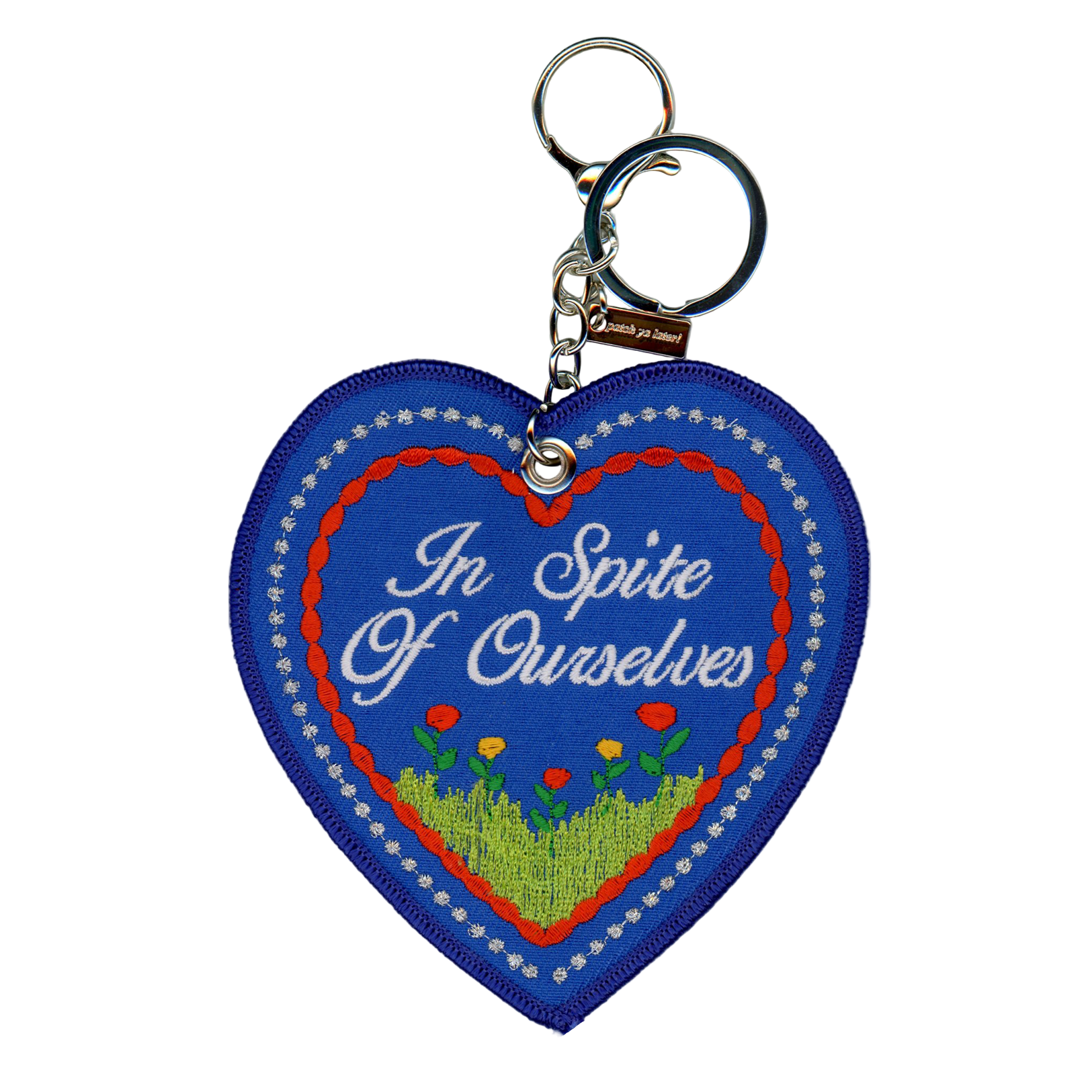 Heart-shaped keychain with 'In Spite Of Ourselves' text on a blue background