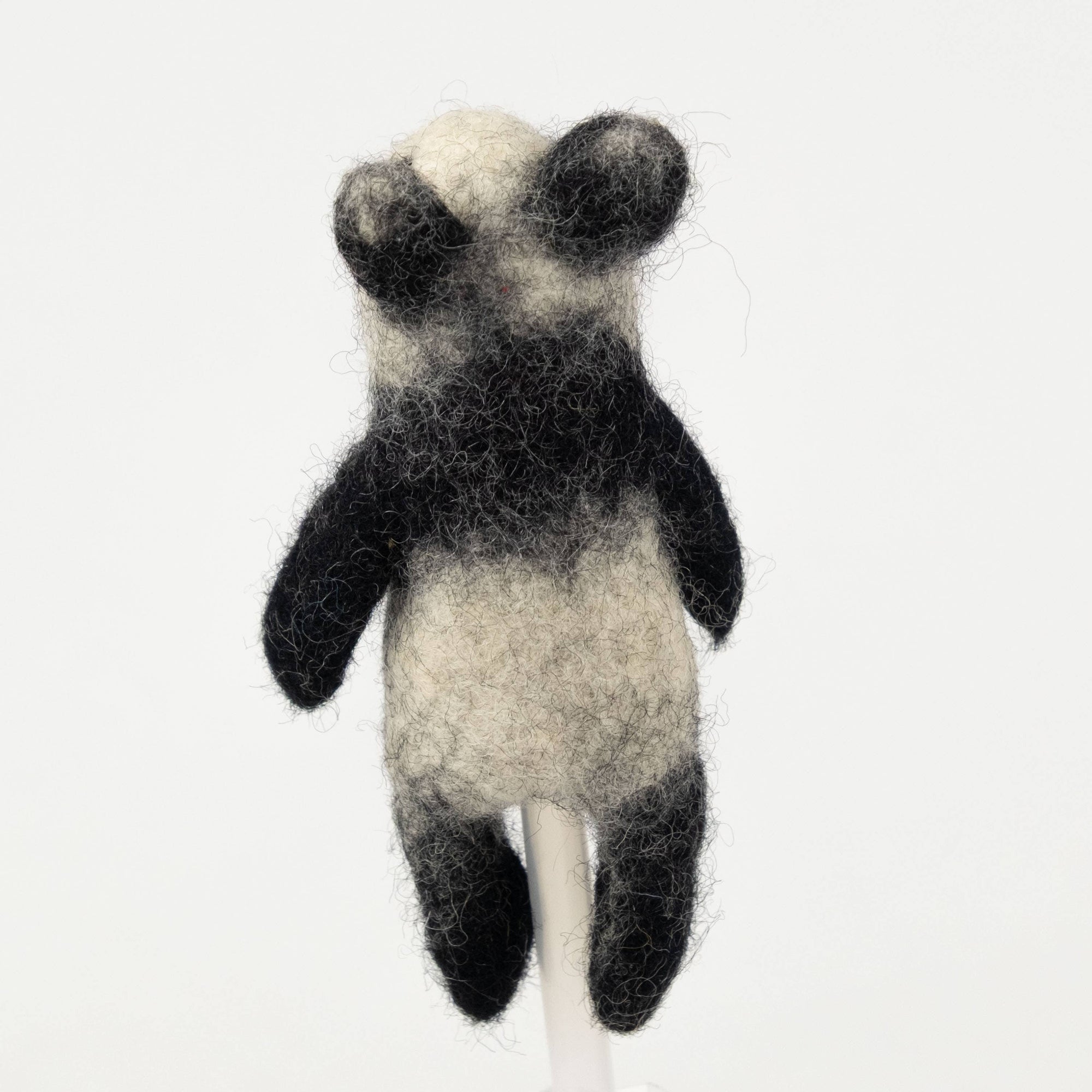 Handcrafted black and white panda toy on a white background
