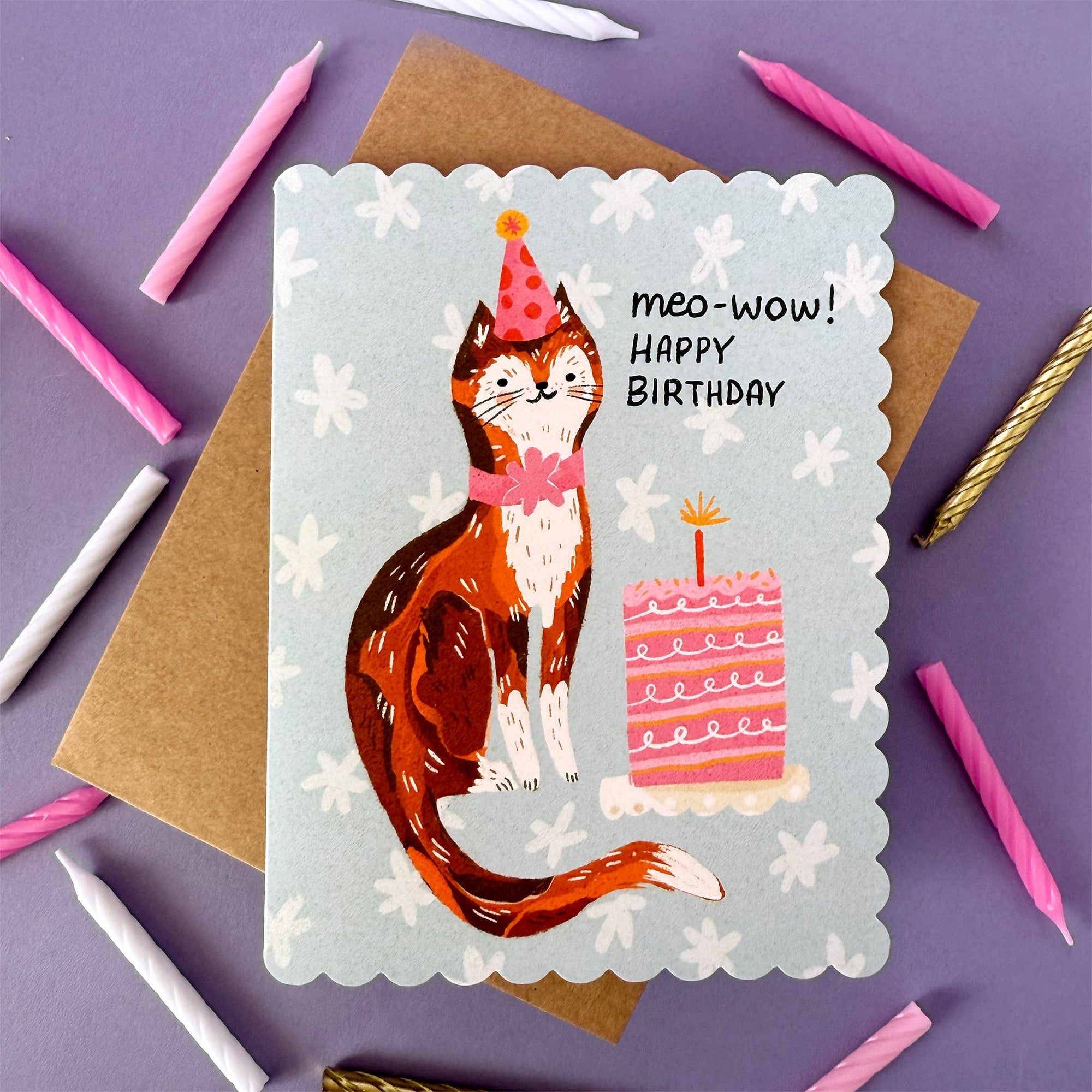 Birthday card with a cat illustration and 'meo-wow! Happy Birthday' text on a purple background with candles.