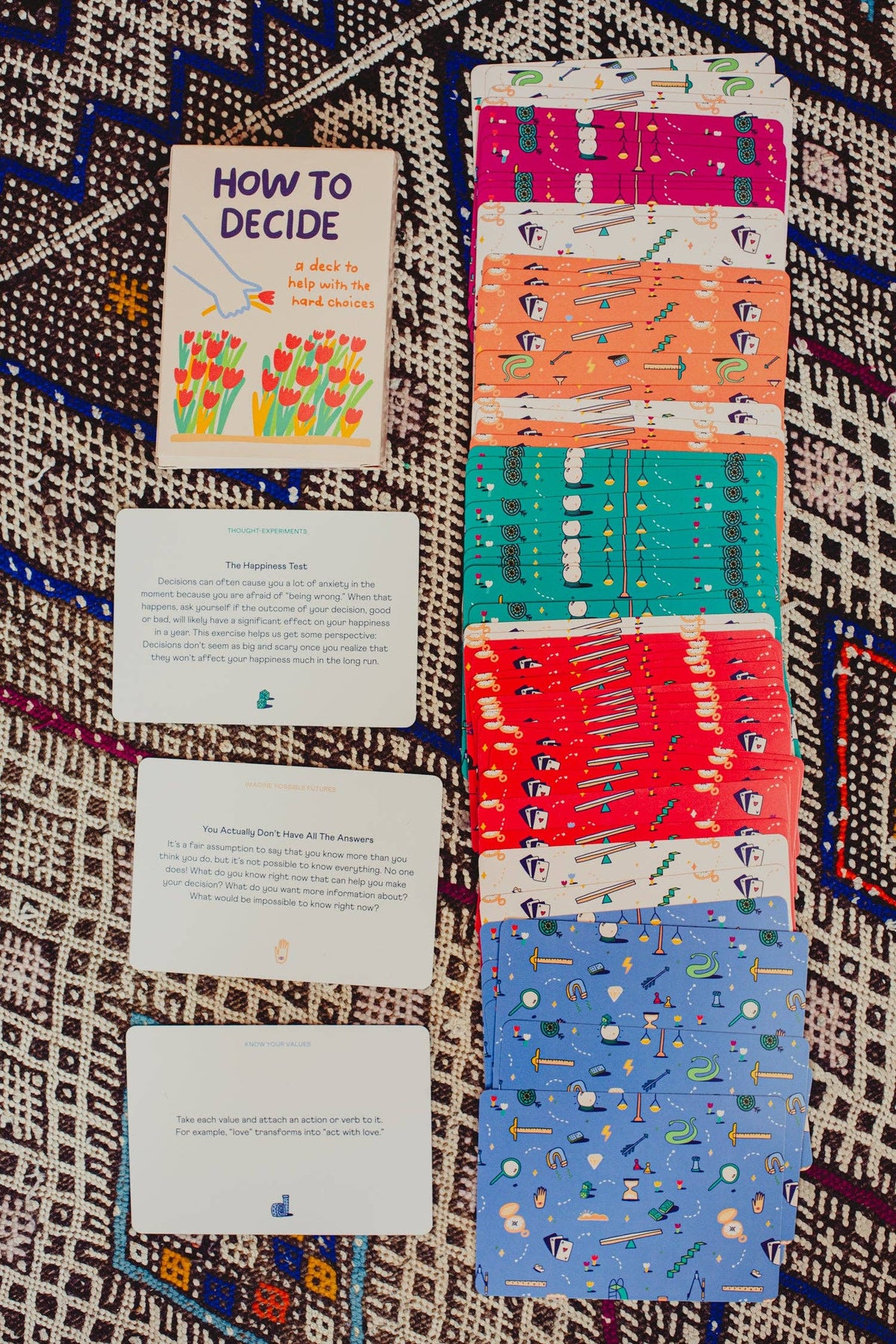 Set of patterned cards and a book titled 'How to Decide' on a textured fabric background