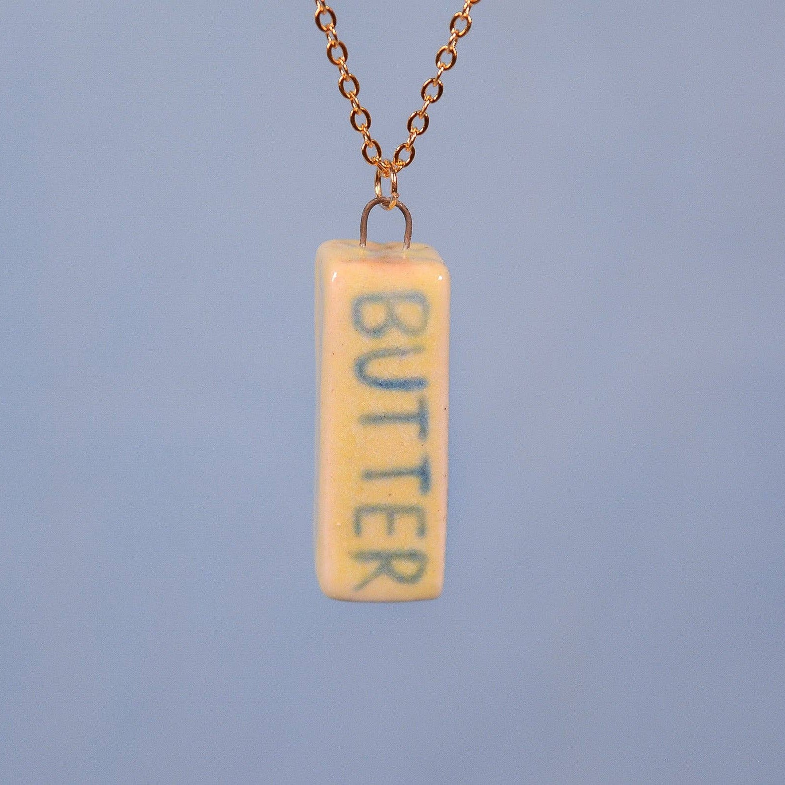 Necklace with a pendant labeled 'BUTTER' on a blue background