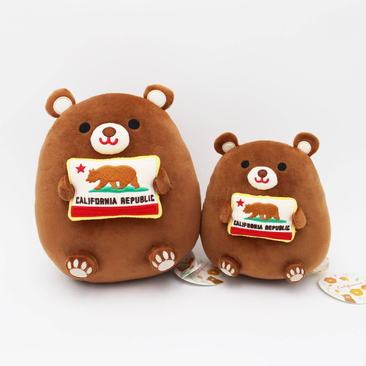 Two brown plush bear toys with embroidered California Republic flags on their chests, photographed on a clean white background.