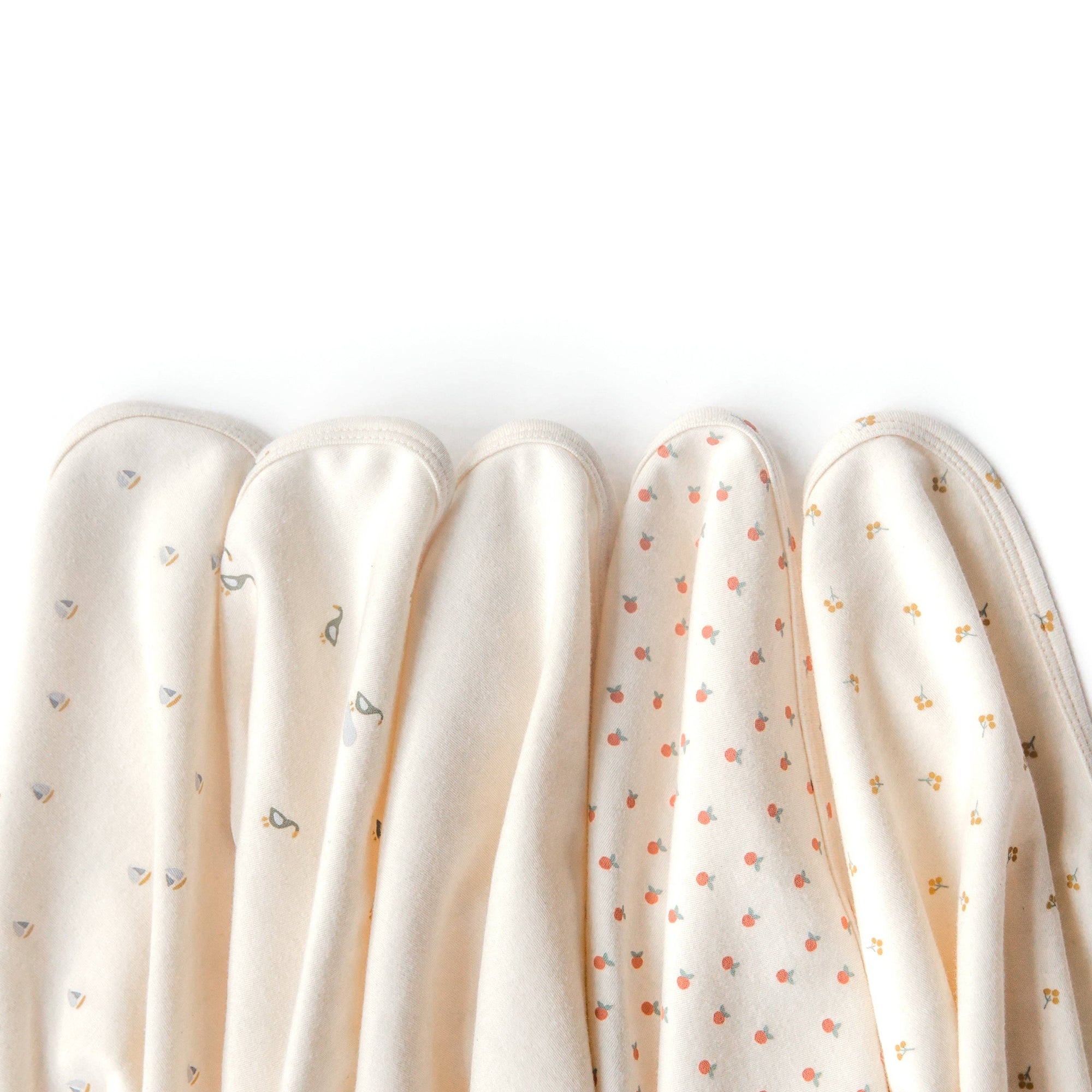 Five swaddles with different patterns on a white background