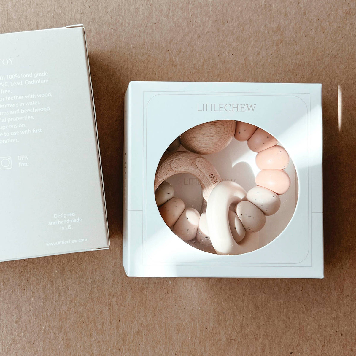 Silver box with a circular design on a beige surface