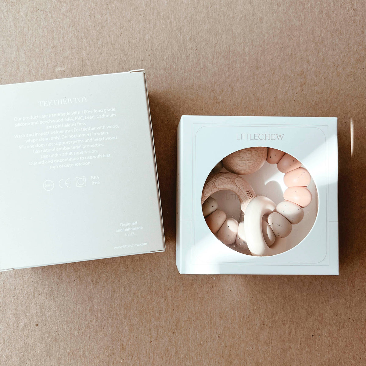Silver box with a circular design on a beige surface