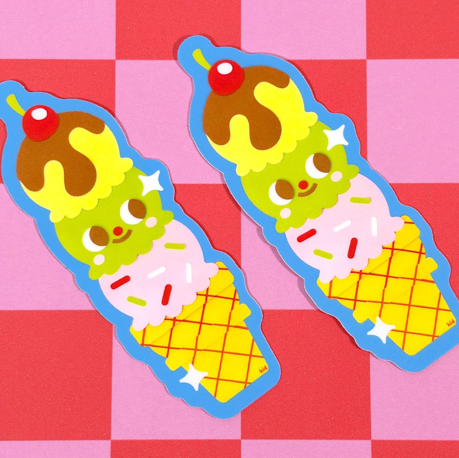 Two cartoon ice cream cones with faces on a pink and red checkered background