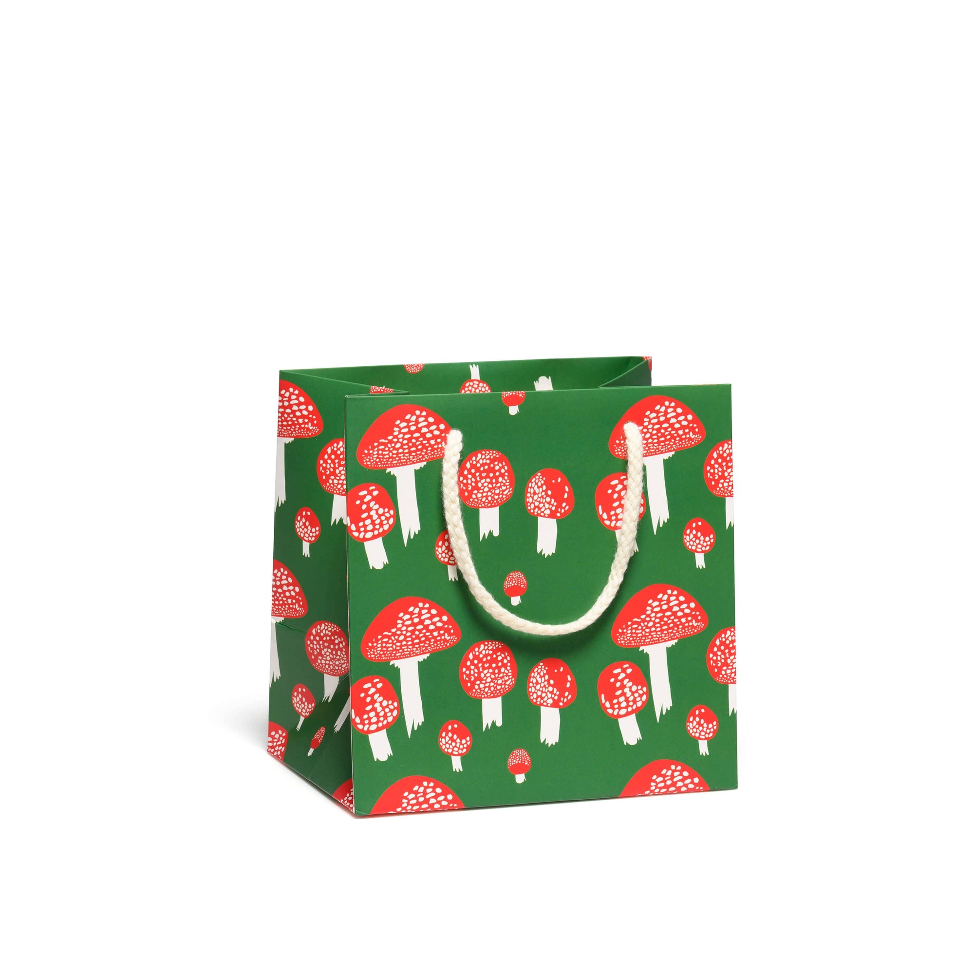 Green gift bag with red and white mushroom pattern on a white background
