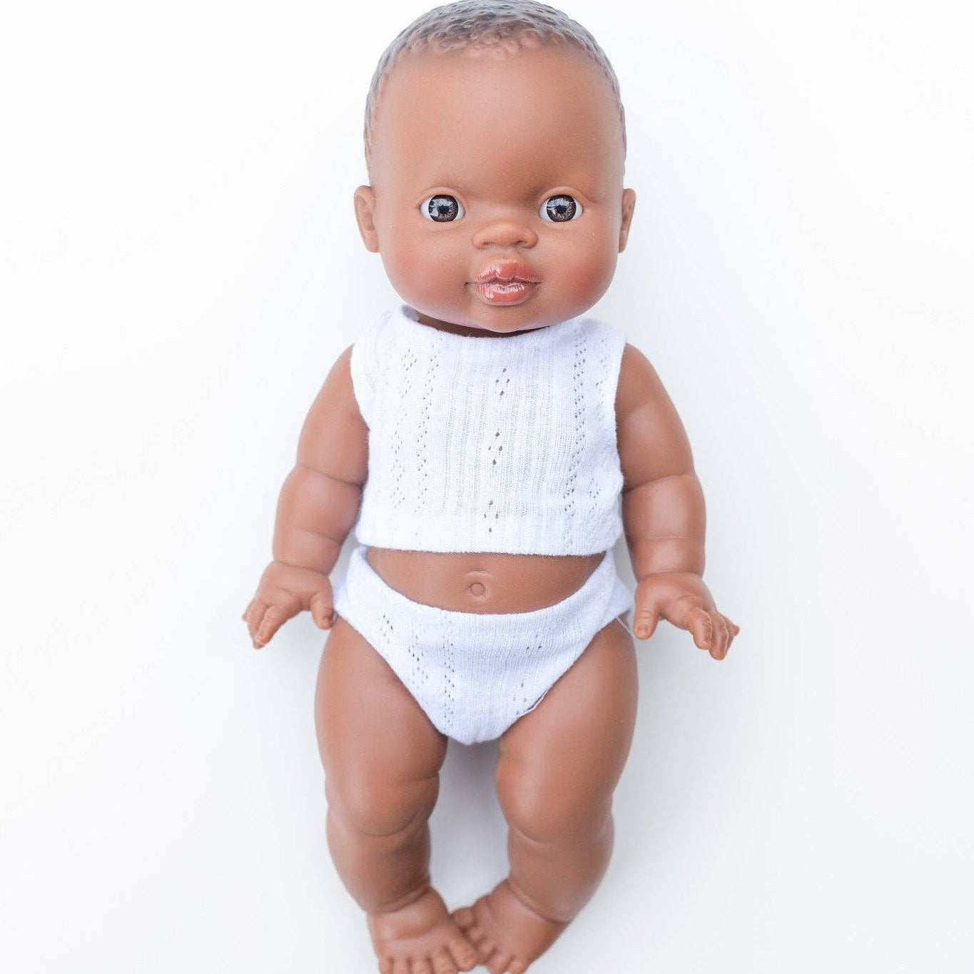 Baby doll with a white outfit on a white background