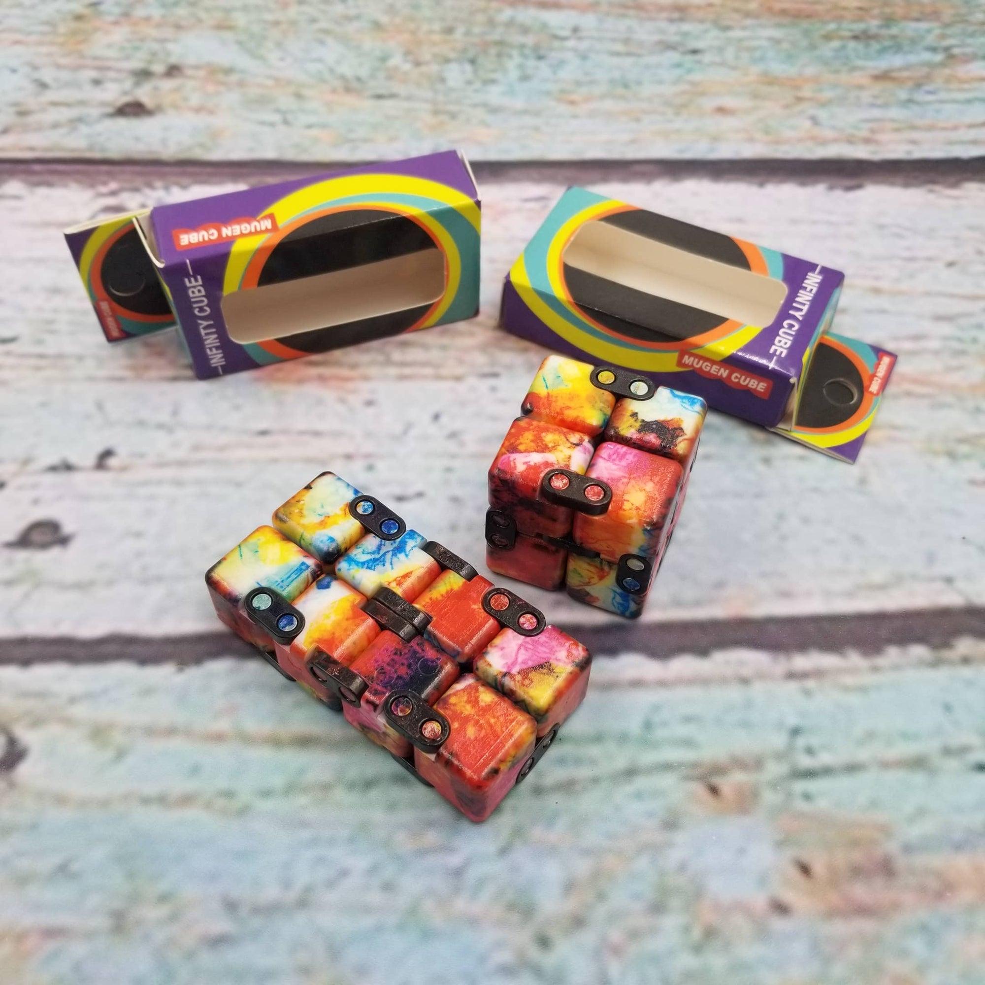 Colorful fidget cube with packaging on a wooden surface