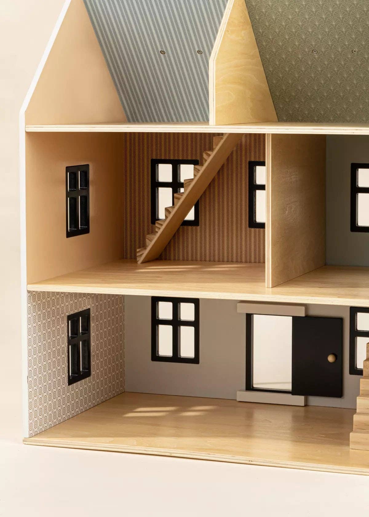 Detailed model of a dollhouse with wooden structure and windows.