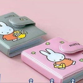 Two cartoon character wallets, one pink and one gray, on a pink background.
