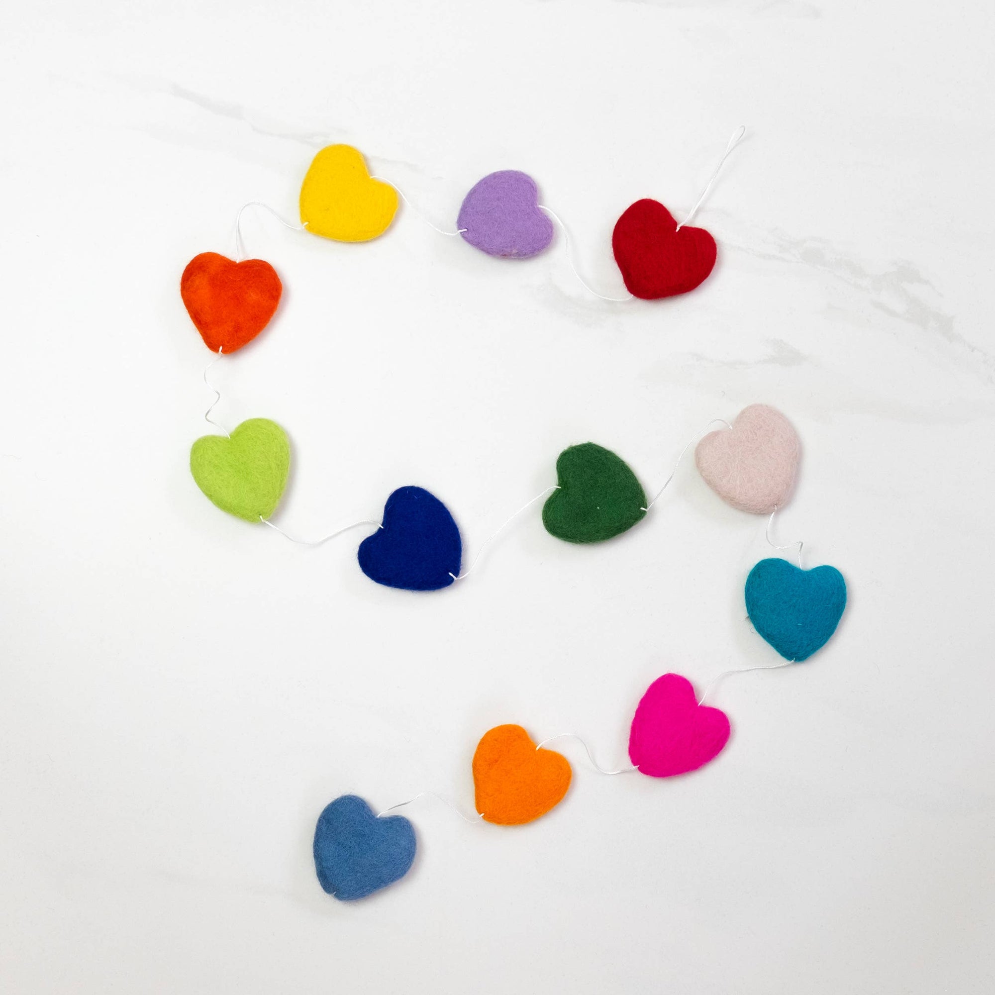 Colorful heart-shaped felt garland on a white background