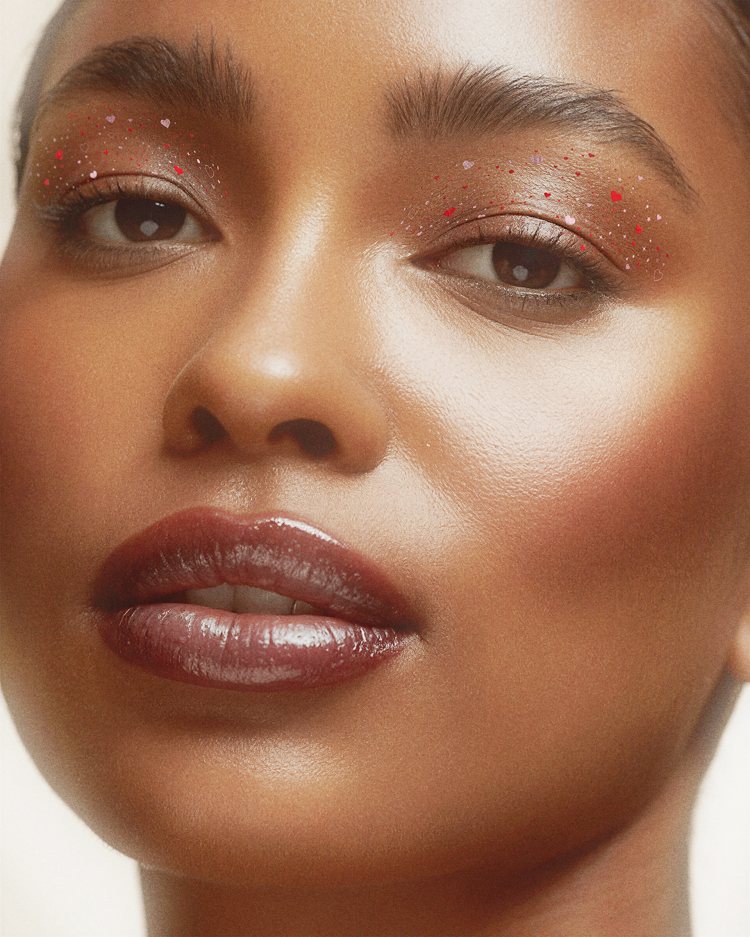 Close-up of a person's face with makeup on a neutral background