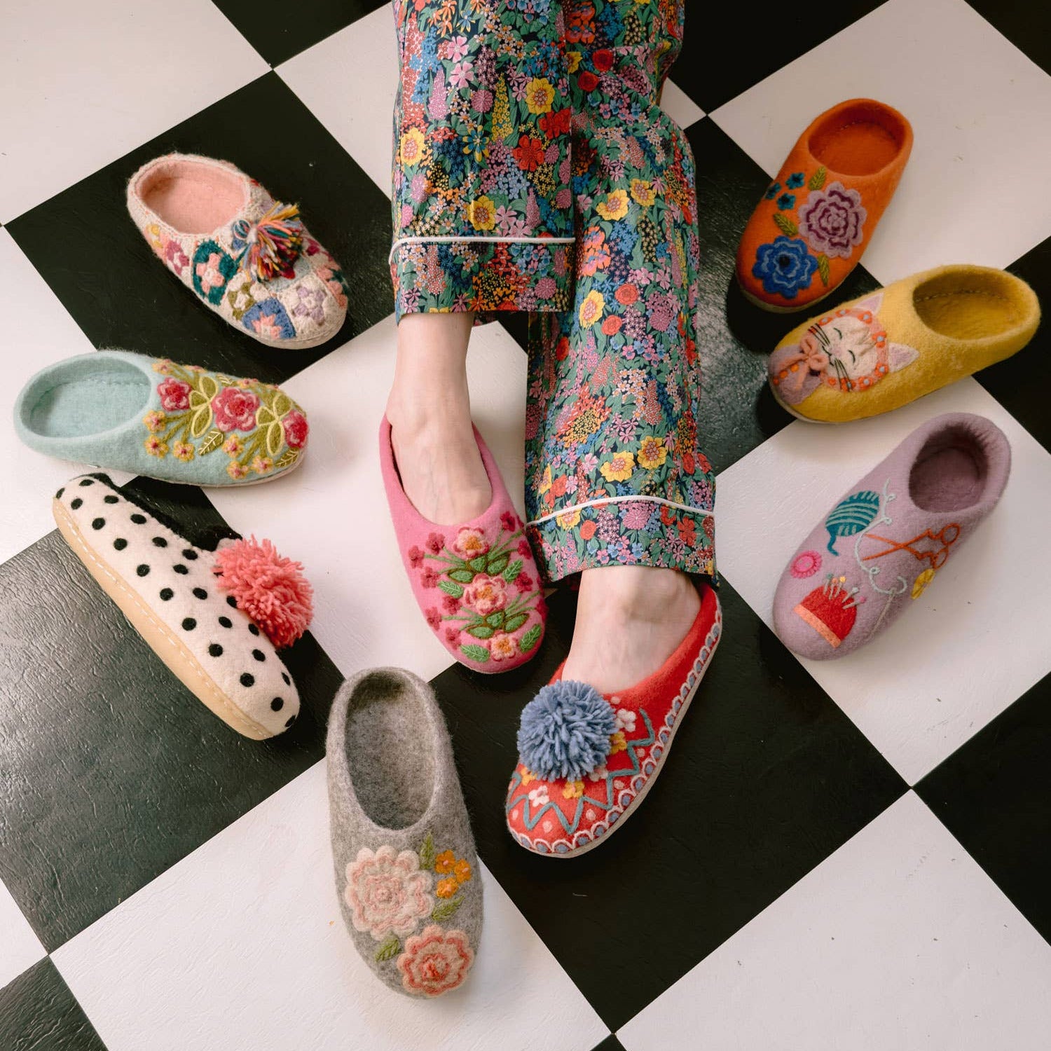 Colorful slippers with floral designs on a checkered floor